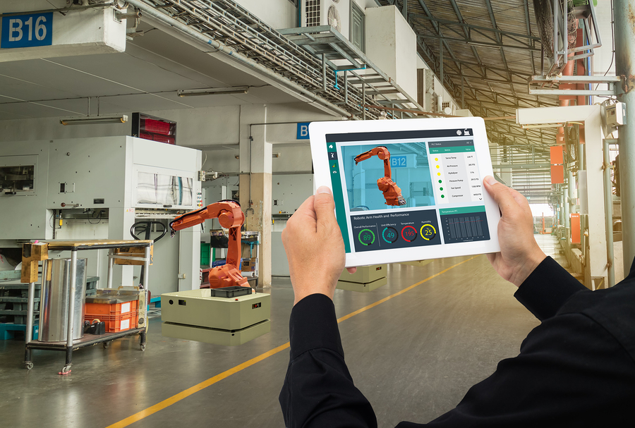 engineer using software (augmented, virtual reality) in tablet to monitoring machine in real time.Smart factory use Automation robot arm in automotive manufacturing