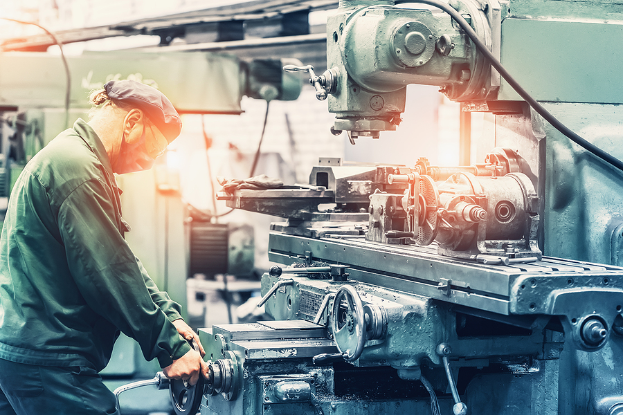 Factory worker using grinder machine tool in metal work factory workshop. Heavy industry and Manufacturing Challenges concept.