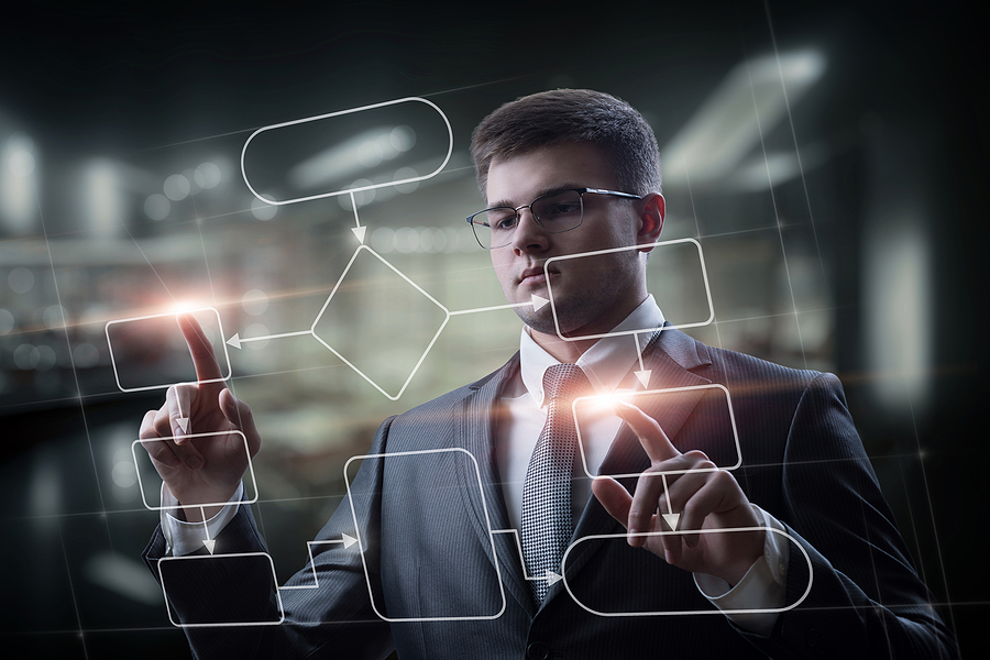 programmer works on a virtual computer screen with a program flowchart demonstrating ERP software implementation