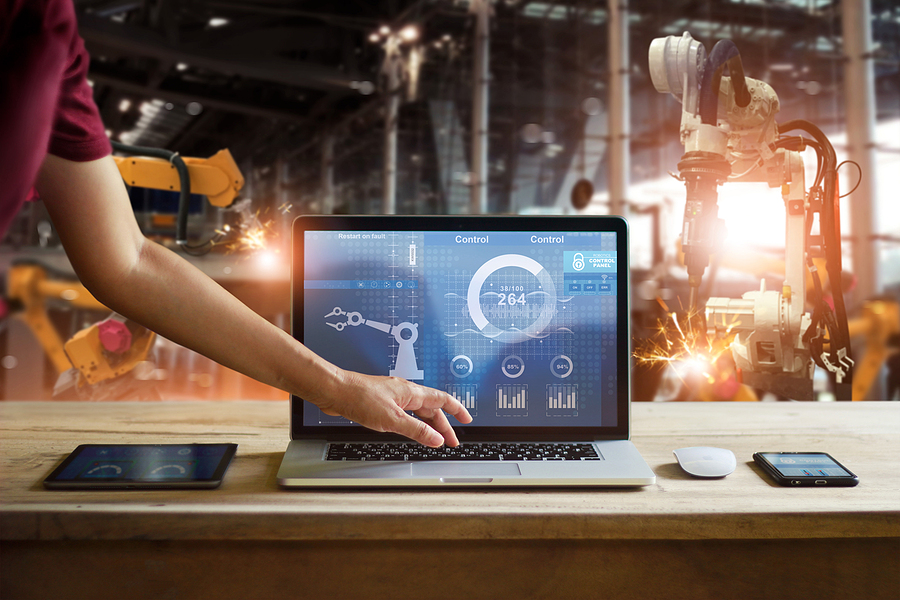 Engineer touching laptop check and control welding robotics automatic arms machine in intelligent factory automotive industrial with monitoring system software. Digital manufacturing operation. Manufacturing management.