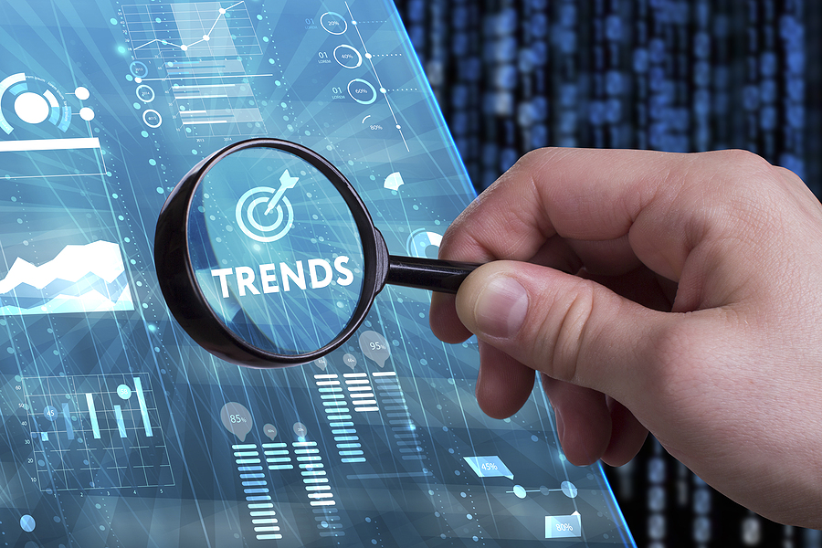 Young businessman working on a virtual screen of the future and sees the inscription: Trends representing ERP Trends